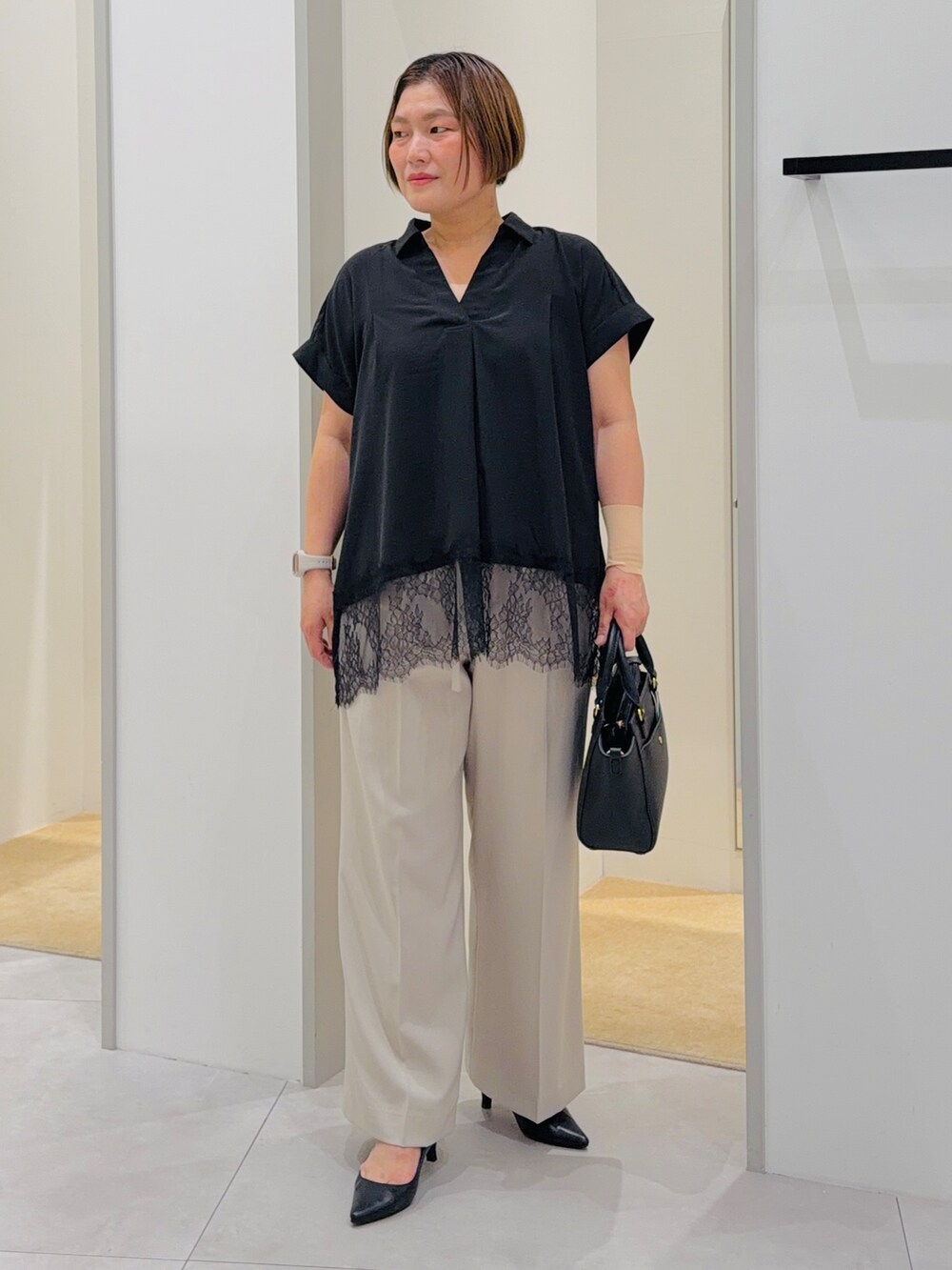 ブラック系のシャツ/ブラウス、ベージュ系のその他パンツ、ブラック系のトートバッグを着用したレディースの夏コーディネートの2枚目の写真