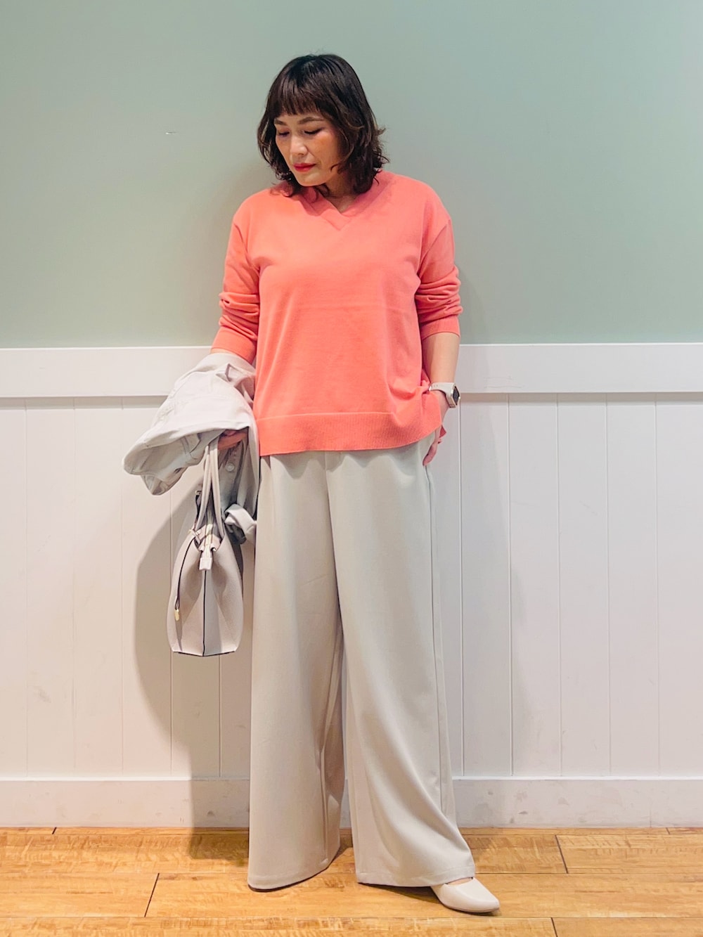 グレー系のデニムジャケット、ピンク系のニット/セーター、グレー系のトートバッグを着用したレディースの春コーディネートの2枚目の写真