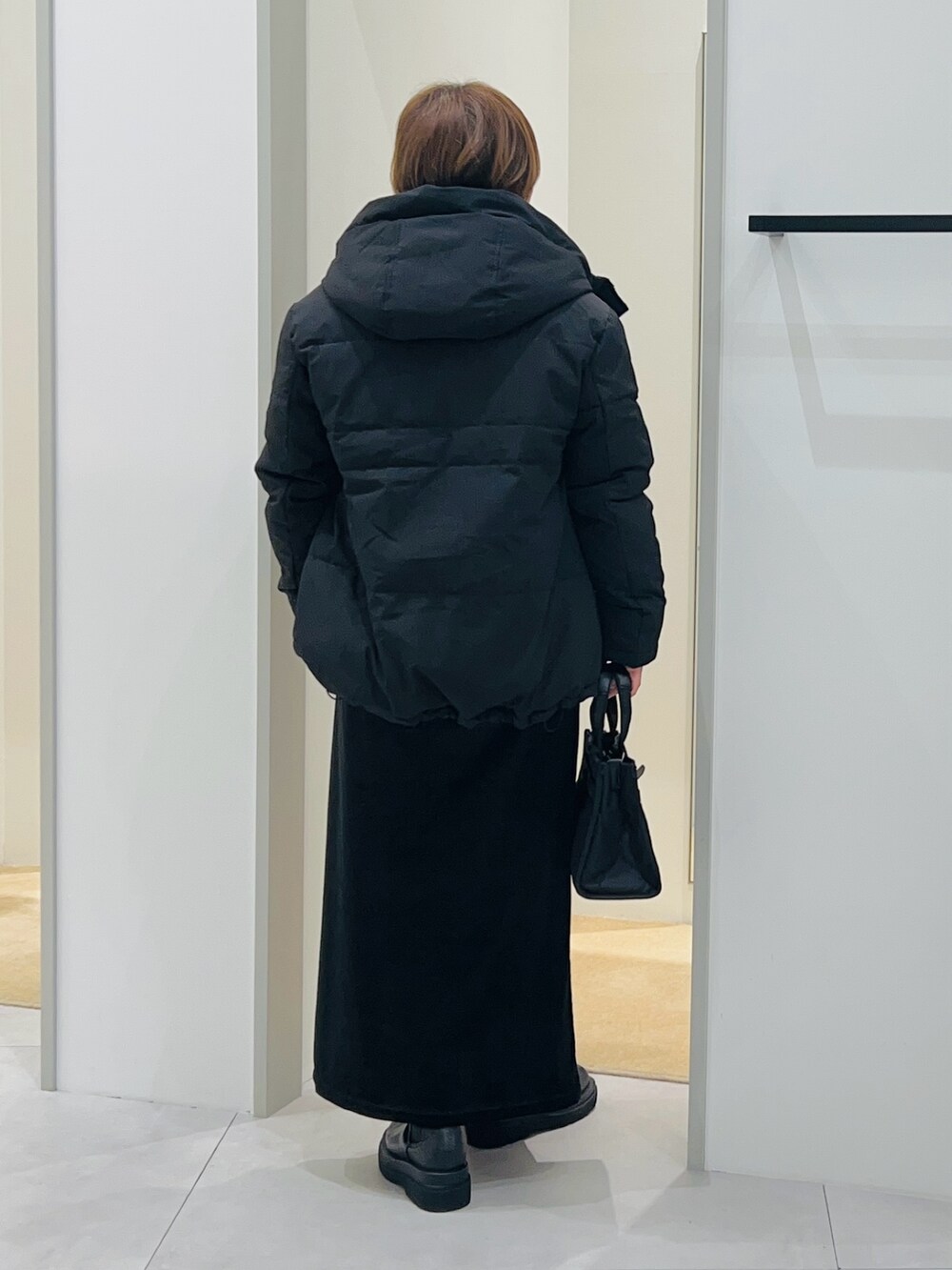 ブラック系のシャツ/ブラウス、ブラック系のスカート、ブラック系のブーツを着用したレディースの秋コーディネートの5枚目の写真