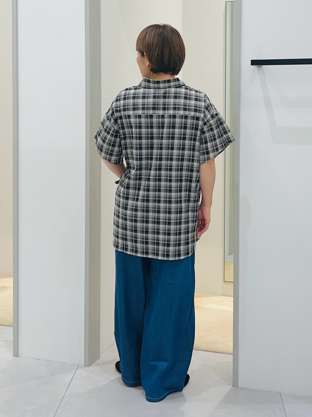 ブラック系のシャツ/ブラウス、ブルー系のその他パンツ、ブラック系のスニーカーを着用したレディースの夏コーディネートの3枚目の写真