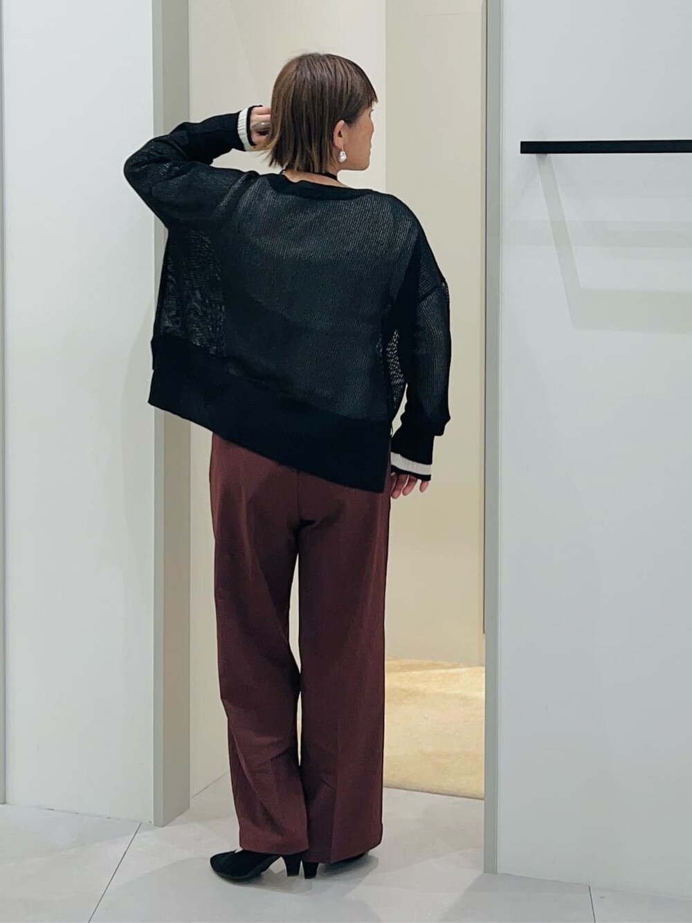 ブラック系のニット/セーター、ホワイト系のニット/セーター、ブラウン系のその他パンツを着用したレディースの春コーディネートの3枚目の写真