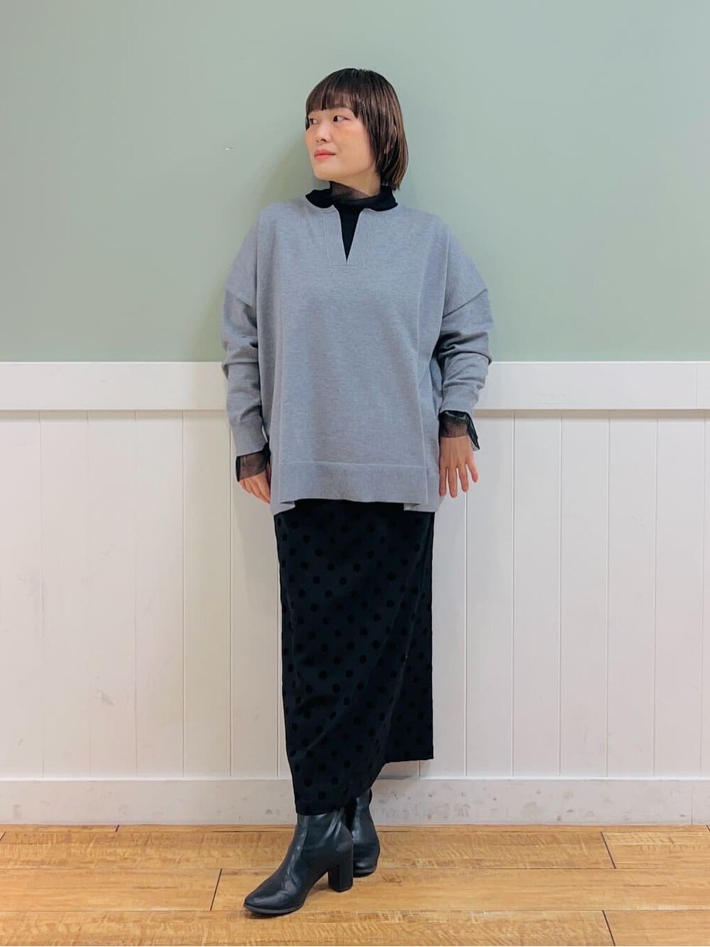 グレー系のニット/セーター、ブラック系のTシャツ/カットソー、グレー系のスカートを着用したレディースの冬コーディネートの4枚目の写真