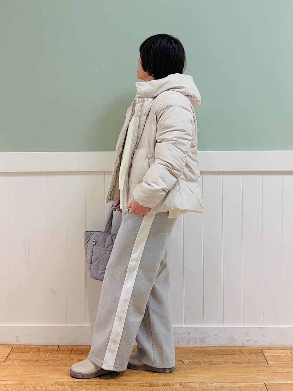 ベージュ系のダウンジャケット/コート、ホワイト系のニット/セーター、グレー系のその他パンツを着用したレディースの冬コーディネートの3枚目の写真