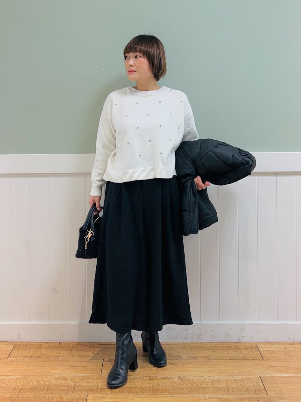 ブラック系のその他アウター、ホワイト系のニット/セーター、ブラック系のその他パンツを着用したレディースの冬コーディネートの3枚目の写真