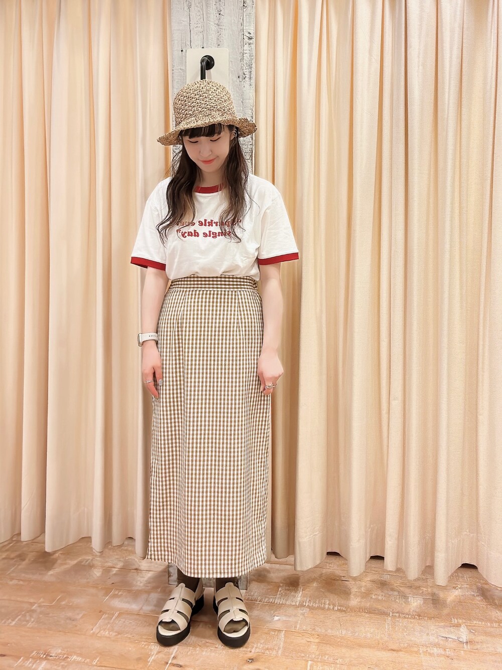 ホワイト系のTシャツ/カットソー、グレー系のサンダル、イエロー系のスカートを着用したレディースの春コーディネートの3枚目の写真