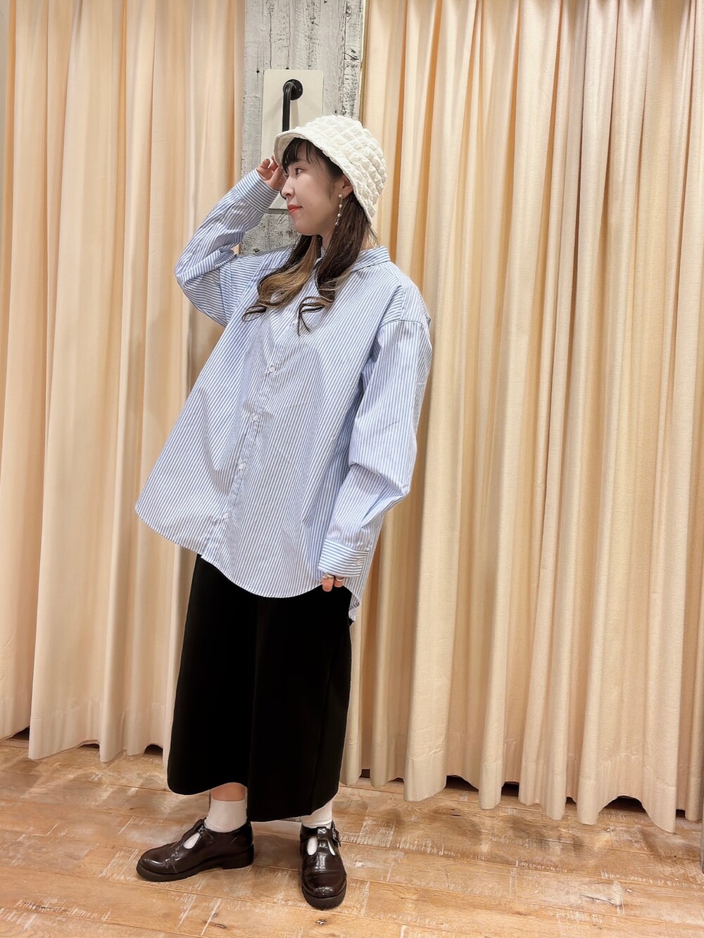 ブルー系のシャツ/ブラウス、ブラック系のスカート、ホワイト系のハットを着用したレディースの春コーディネートの3枚目の写真