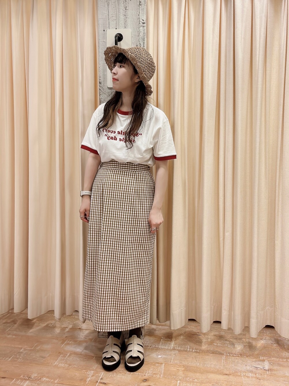 ホワイト系のTシャツ/カットソー、グレー系のサンダル、イエロー系のスカートを着用したレディースの春コーディネートの2枚目の写真