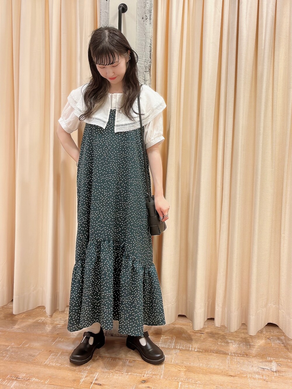 ブラック系のバレエシューズ、グリーン系のワンピース、ホワイト系のシャツ/ブラウスを着用したレディースの夏コーディネートの2枚目の写真