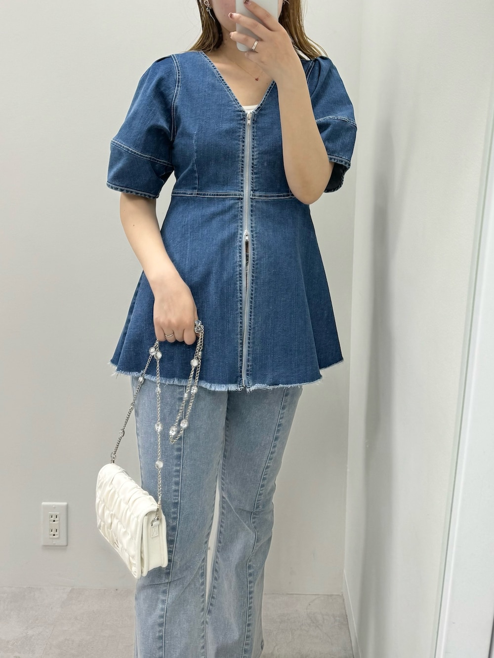 ブルー系のシャツ/ブラウス、ブルー系のデニムパンツ、ホワイト系のショルダーバッグを着用したレディースの春コーディネートの2枚目の写真