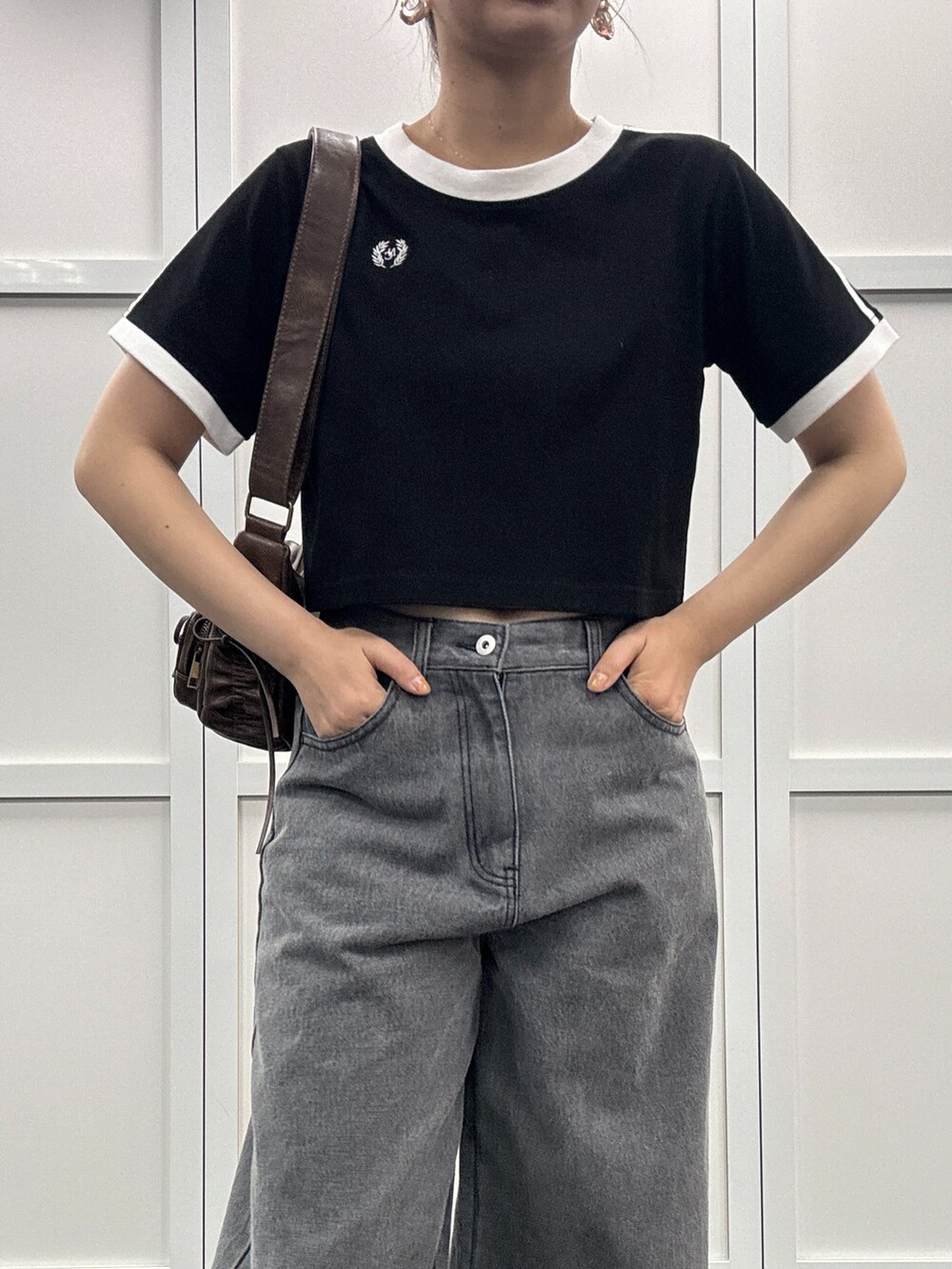 ブラック系のデニムパンツ、ブラック系のTシャツ/カットソー、ブラウン系のショルダーバッグを着用したレディースの夏コーディネートの2枚目の写真