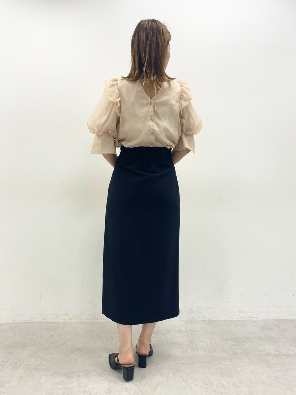 ブラック系のスカート、ベージュ系のシャツ/ブラウス、ブラック系のその他シューズを着用したレディースの夏コーディネートの2枚目の写真