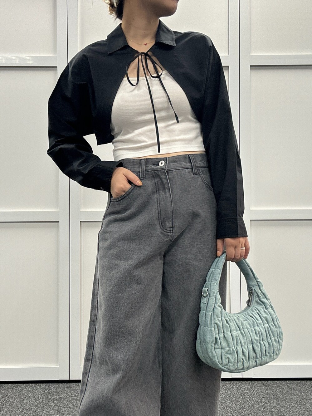 ブラック系のシャツ/ブラウス、ブラック系のデニムパンツ、ブルー系のショルダーバッグを着用したレディースの夏コーディネートの2枚目の写真