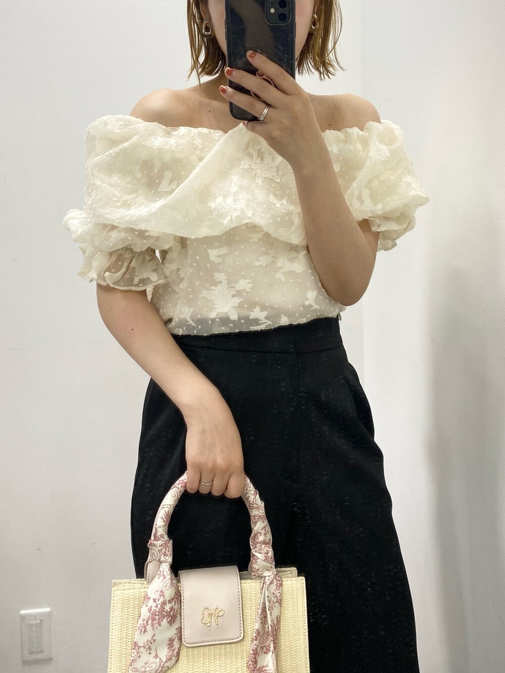 ブラック系のスラックス、ホワイト系のシャツ/ブラウス、ピンク系のショルダーバッグを着用したレディースの春コーディネートの2枚目の写真