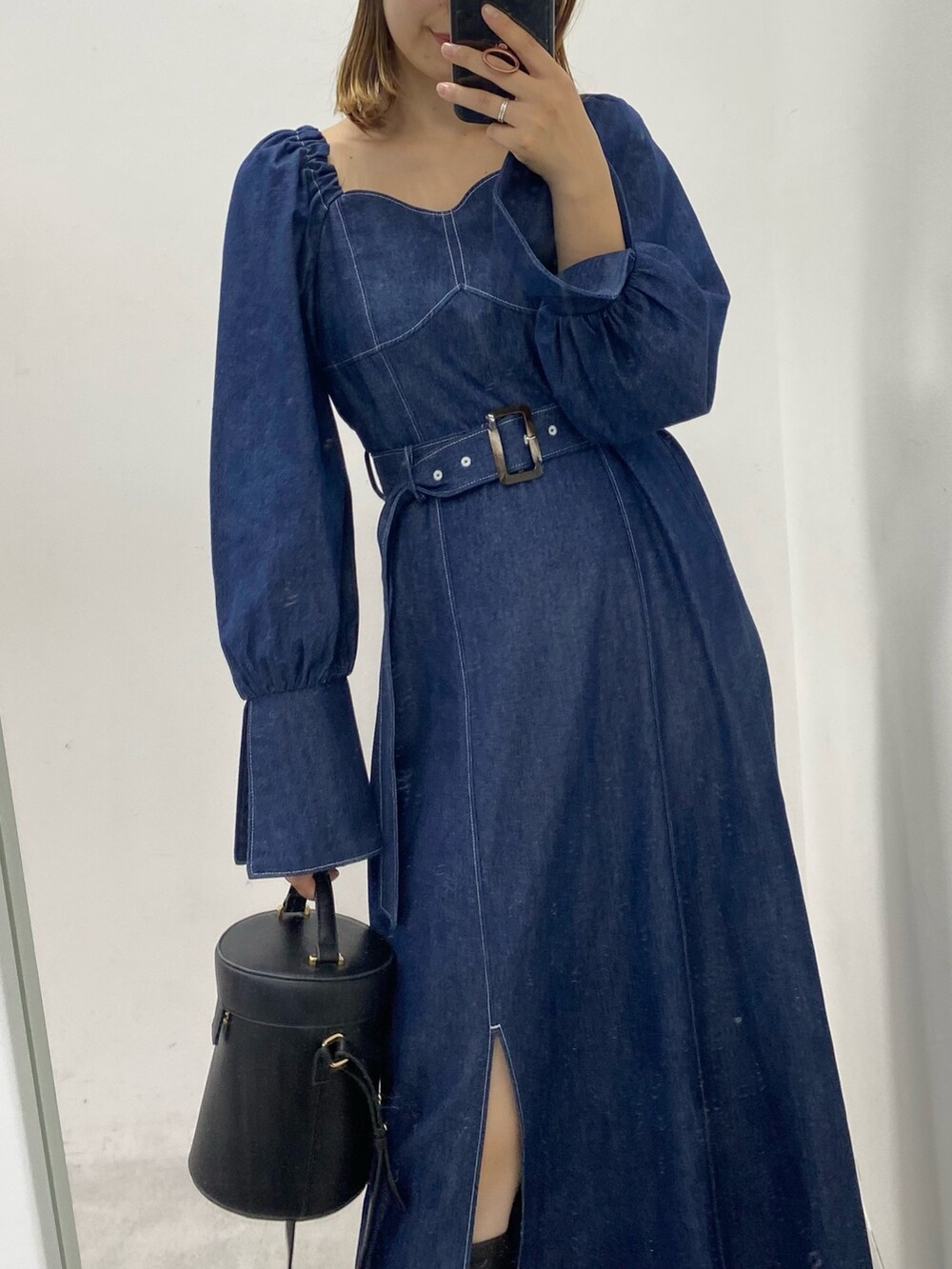 ブルー系のワンピース、ブラック系のブーツを着用したレディースの秋コーディネートの3枚目の写真