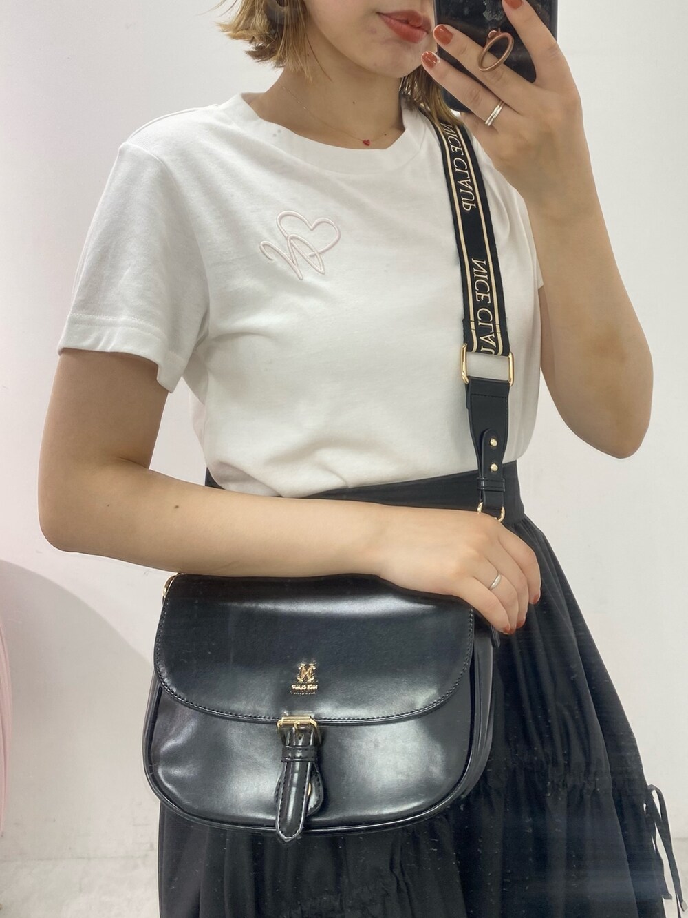 ホワイト系のTシャツ/カットソー、ブラック系のスカートを着用したレディースの夏コーディネートの2枚目の写真