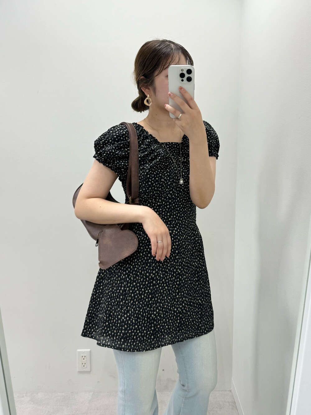 ブラック系のワンピース、ブルー系のデニムパンツを着用したレディースの夏コーディネートの2枚目の写真