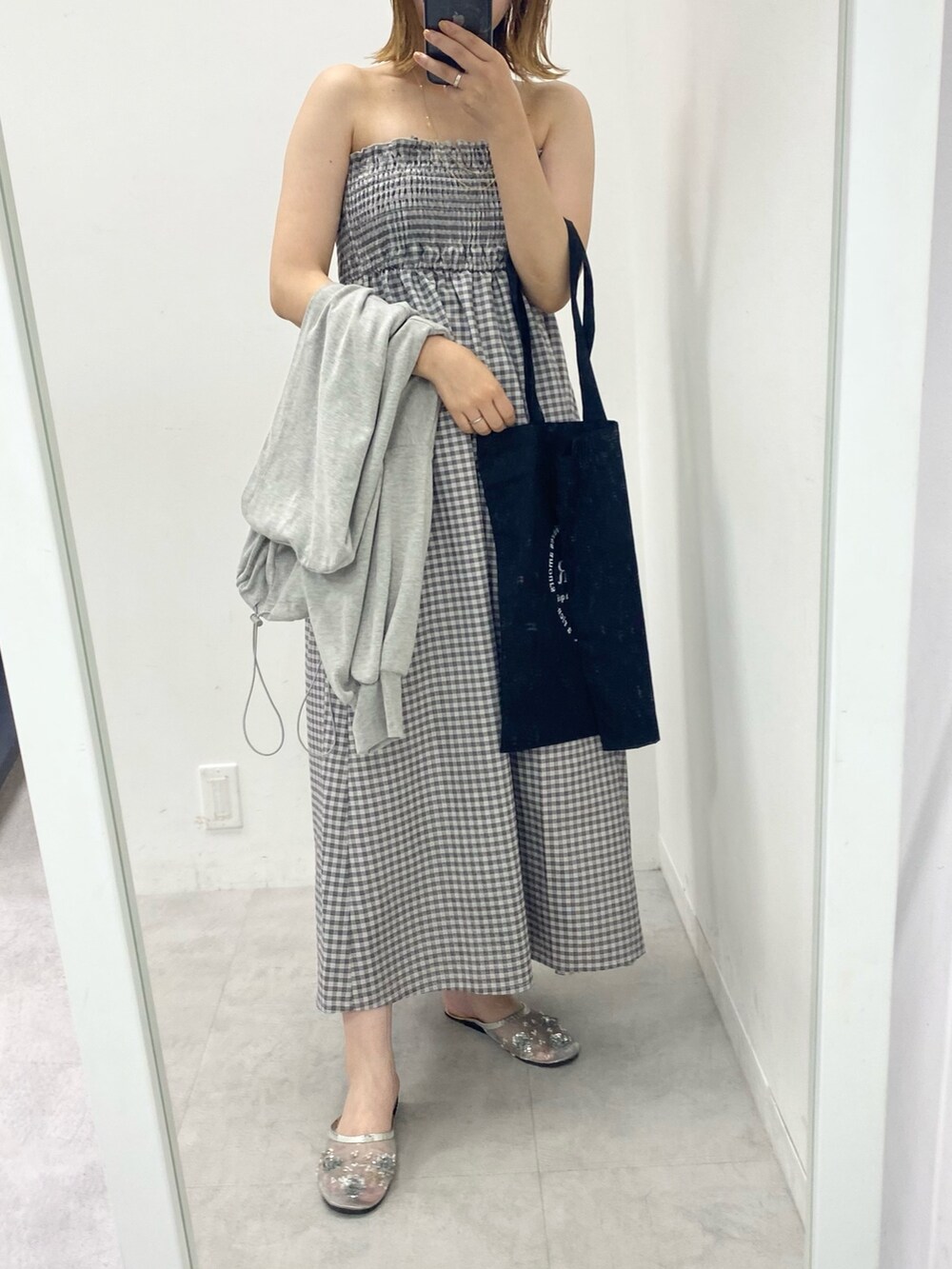 グレー系のパーカー、ブラック系のワンピース、シルバー系のサンダルを着用したレディースの秋コーディネートの2枚目の写真