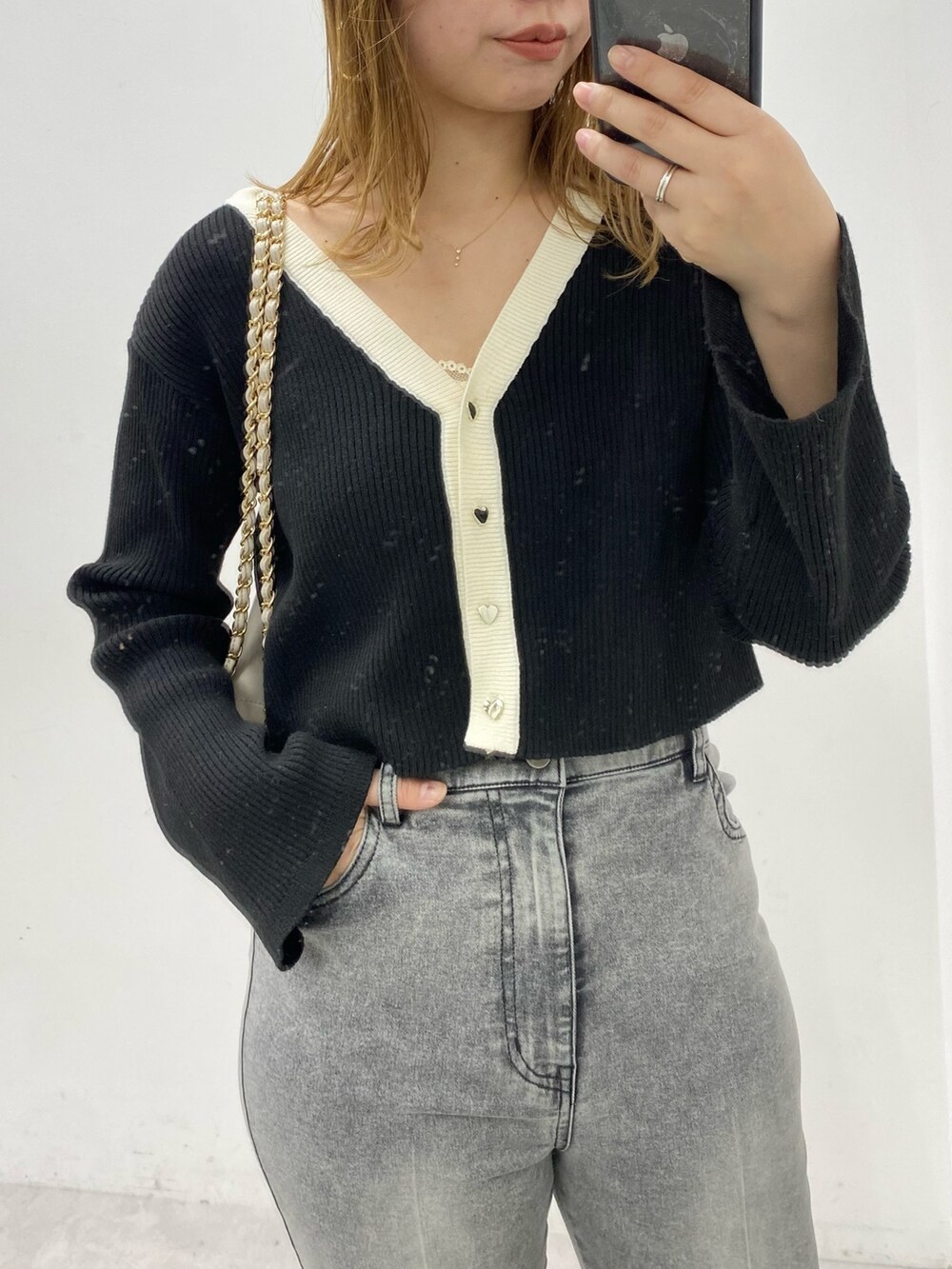 ブラック系のカーディガン/ボレロ、ベージュ系のショルダーバッグ、ブラック系のデニムパンツを着用したレディースの冬コーディネートの2枚目の写真