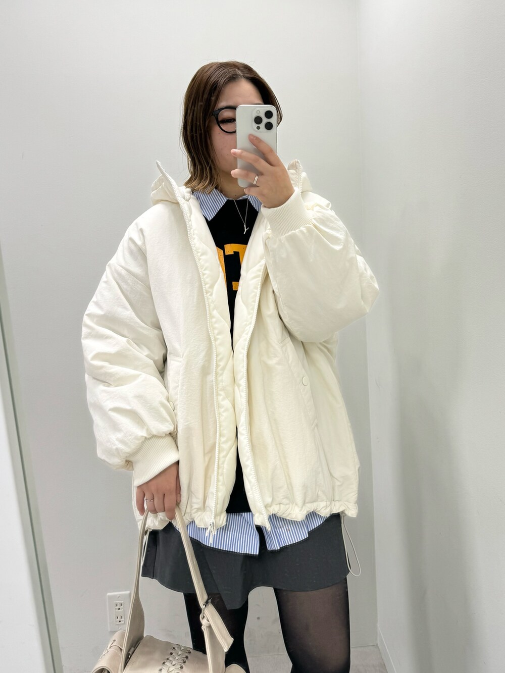 ホワイト系のブルゾン、ホワイト系のショルダーバッグを着用したレディースの冬コーディネートの2枚目の写真