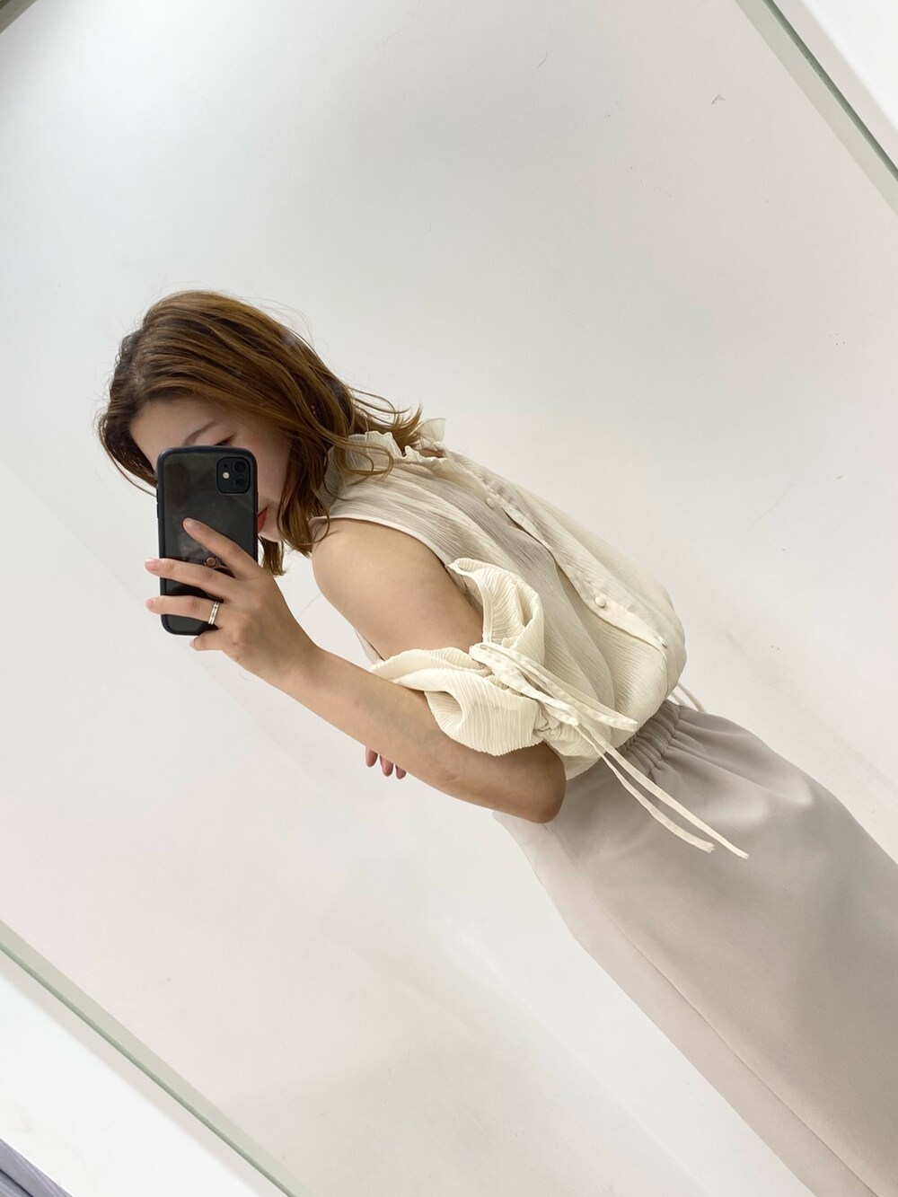 ホワイト系のシャツ/ブラウス、ベージュ系のスカート、ベージュ系のサンダルを着用したレディースの夏コーディネートの3枚目の写真