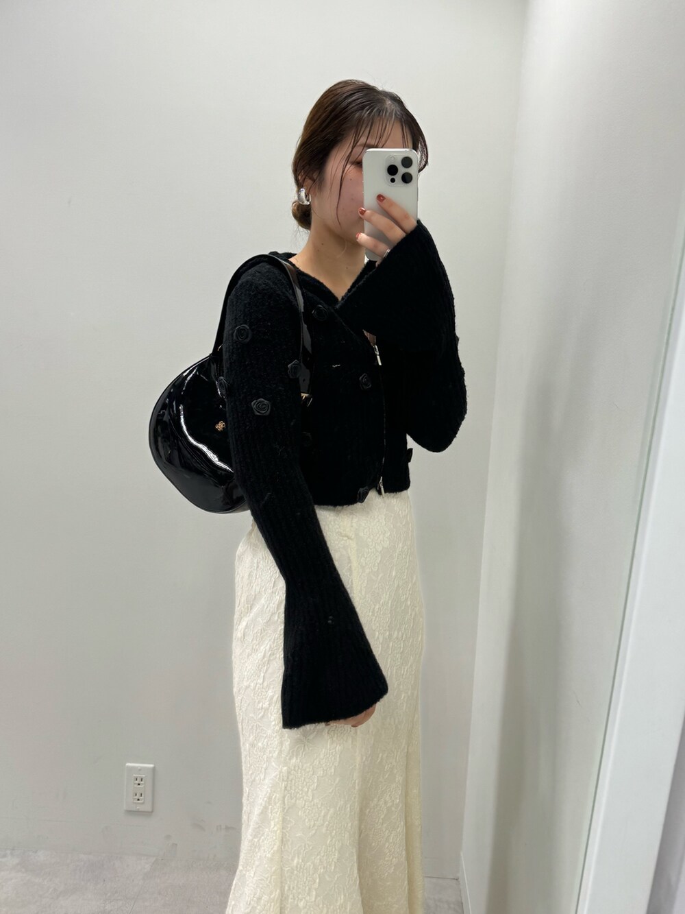 ブラック系のパーカー、ホワイト系のスカート、ブラック系のショルダーバッグを着用したレディースの夏コーディネートの2枚目の写真