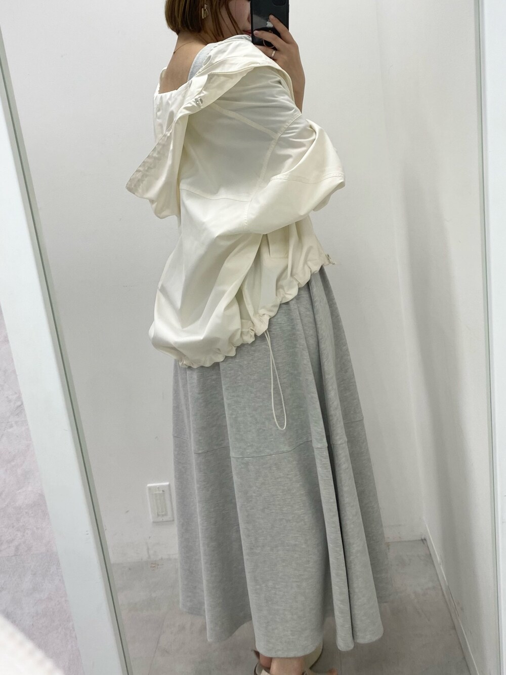 ホワイト系のマウンテンパーカー、グレー系のワンピースを着用したレディースの春コーディネートの3枚目の写真