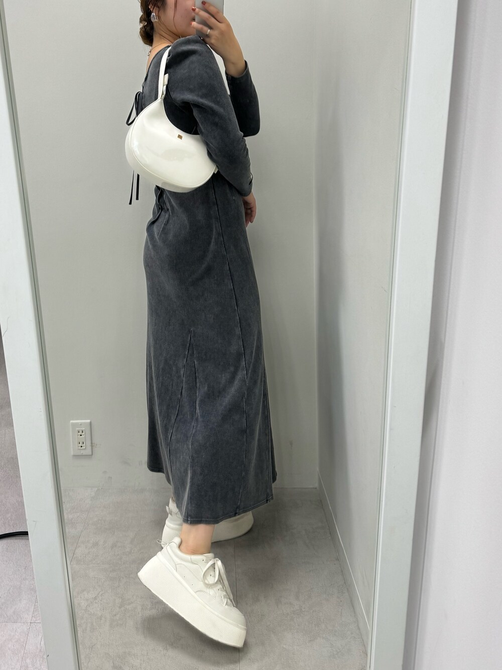 グレー系のワンピース、ホワイト系のスニーカー、ホワイト系のショルダーバッグを着用したレディースの夏コーディネートの2枚目の写真
