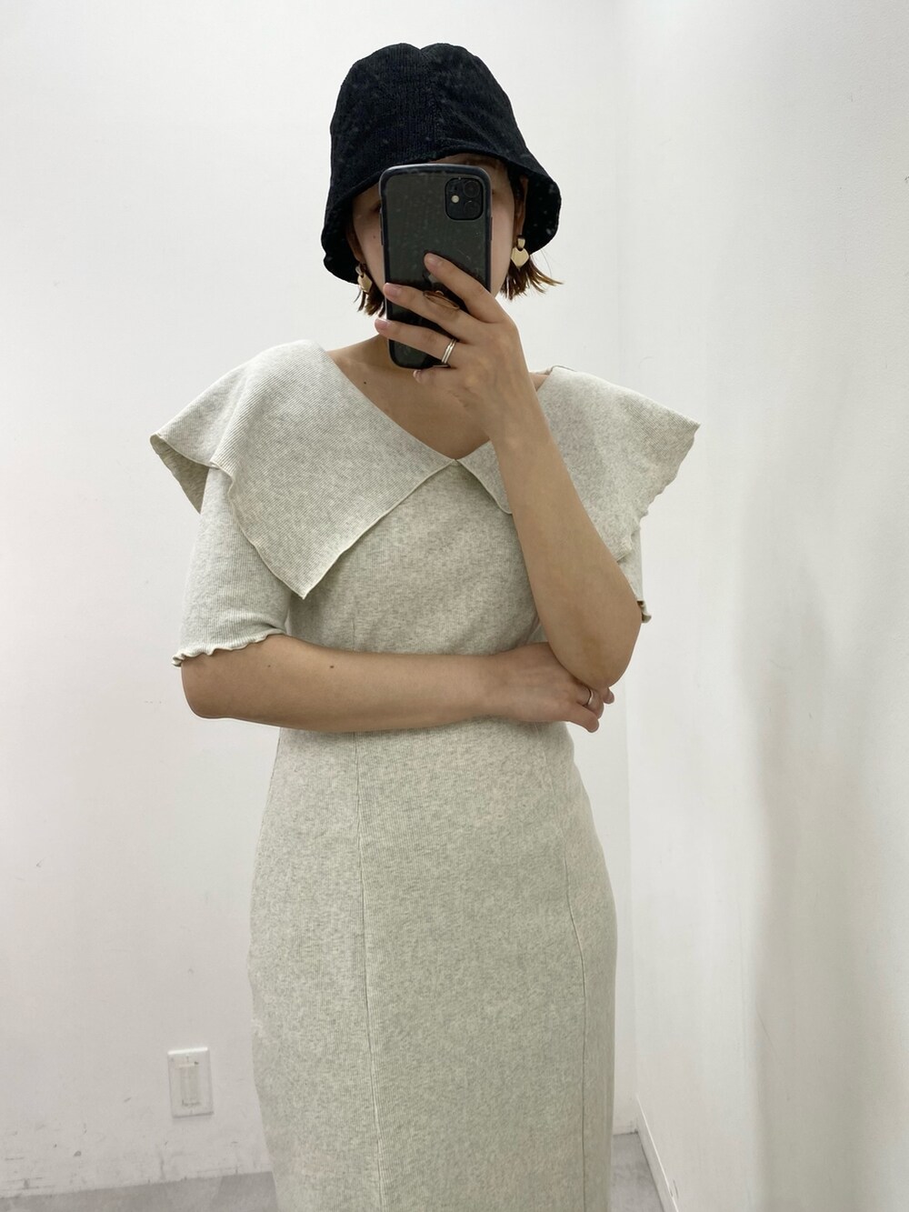 ベージュ系のワンピース、ブラック系のハットを着用したレディースの春コーディネートの2枚目の写真