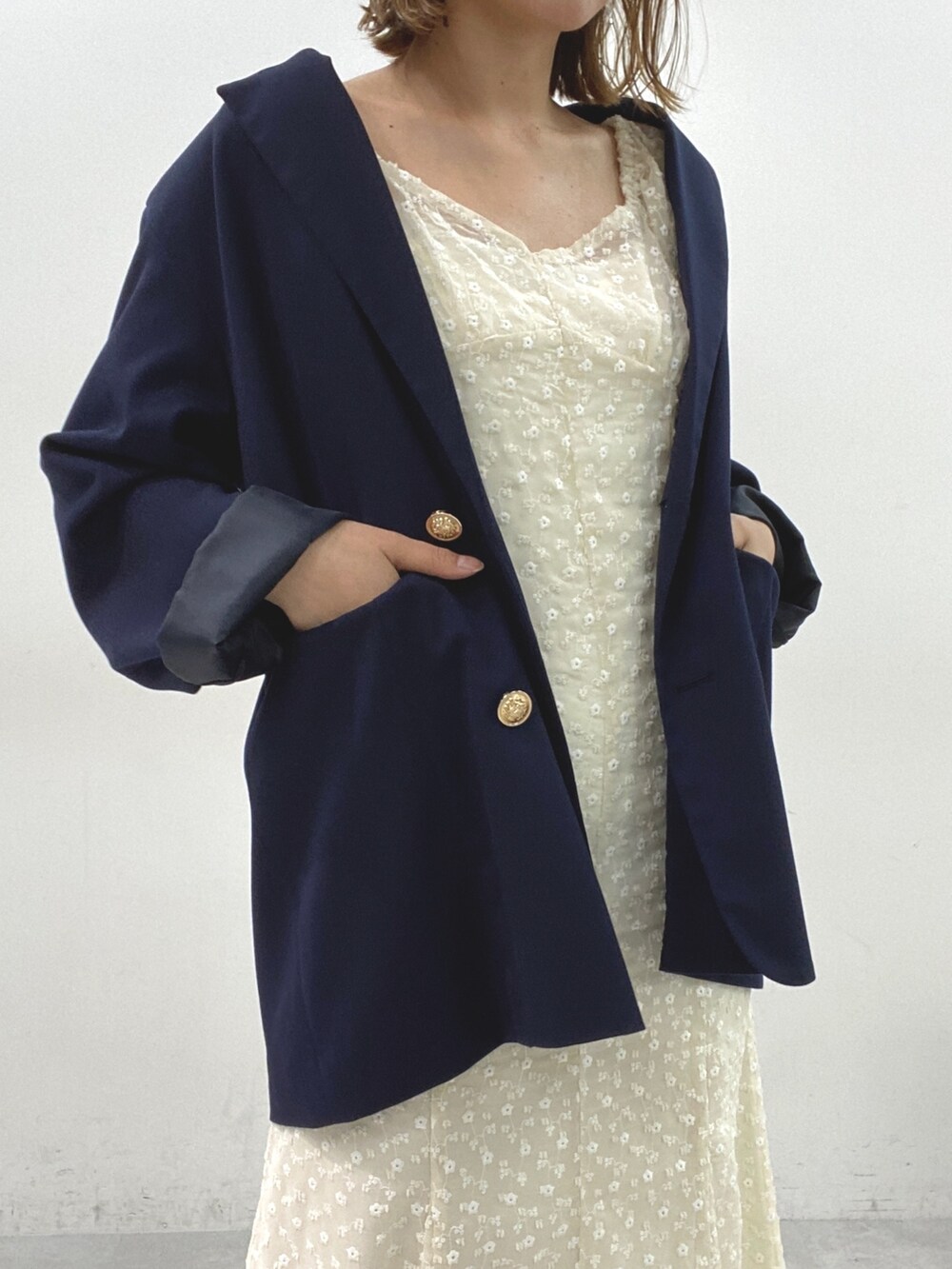 ホワイト系のワンピース、ブルー系のテーラードジャケットを着用したレディースの春コーディネートの3枚目の写真