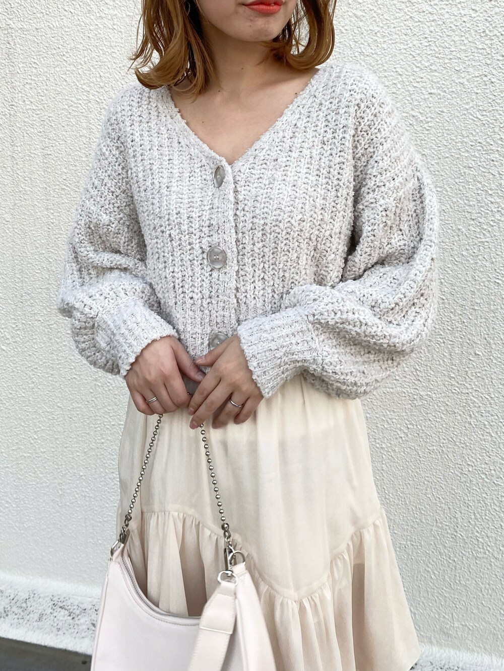 ホワイト系のショルダーバッグ、ホワイト系のスカート、ホワイト系のブーツを着用したレディースの冬コーディネートの4枚目の写真