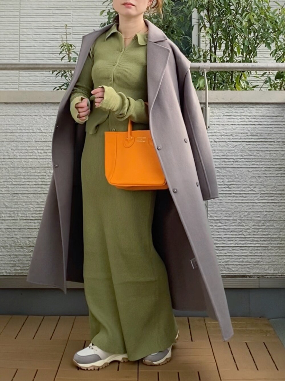 ブラウン系のチェスターコート、グリーン系のカーディガン/ボレロ、グリーン系のスカートを着用したレディースの秋コーディネートの2枚目の写真