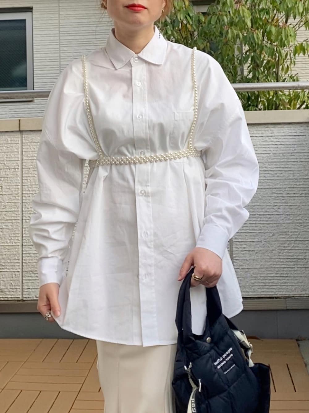 ホワイト系のシャツ/ブラウス、ホワイト系のスカート、ブラック系のショルダーバッグを着用したレディースの春コーディネートの4枚目の写真