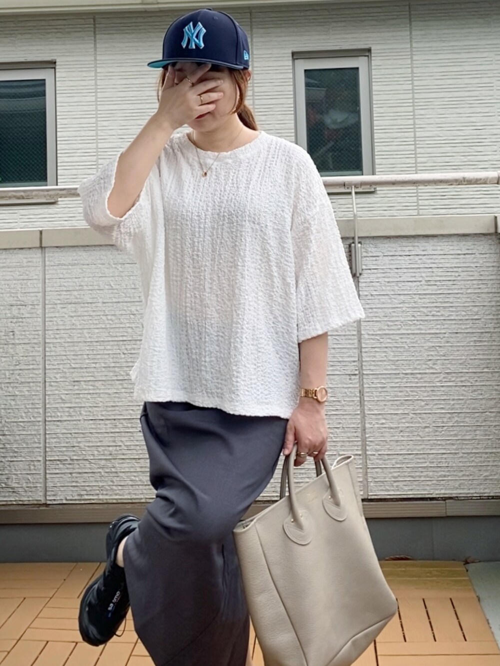 ホワイト系のシャツ/ブラウス、グレー系のスカート、ベージュ系のトートバッグを着用したレディースの夏コーディネートの3枚目の写真