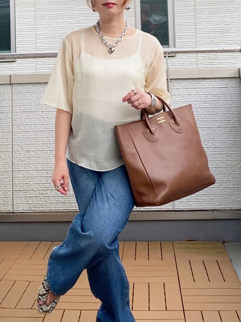 ホワイト系のシャツ/ブラウス、ブルー系のデニムパンツ、ブラウン系のトートバッグを着用したレディースの夏コーディネートの4枚目の写真