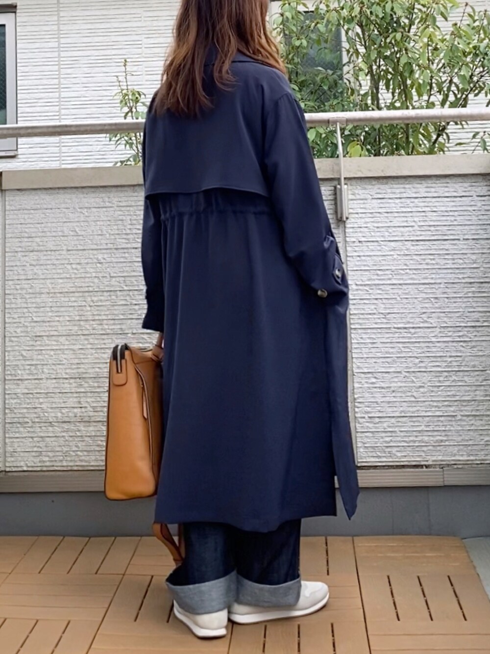ブルー系のサロペット/オーバーオール、ブルー系のトレンチコート、ベージュ系のTシャツ/カットソーを着用したレディースの春コーディネートの2枚目の写真