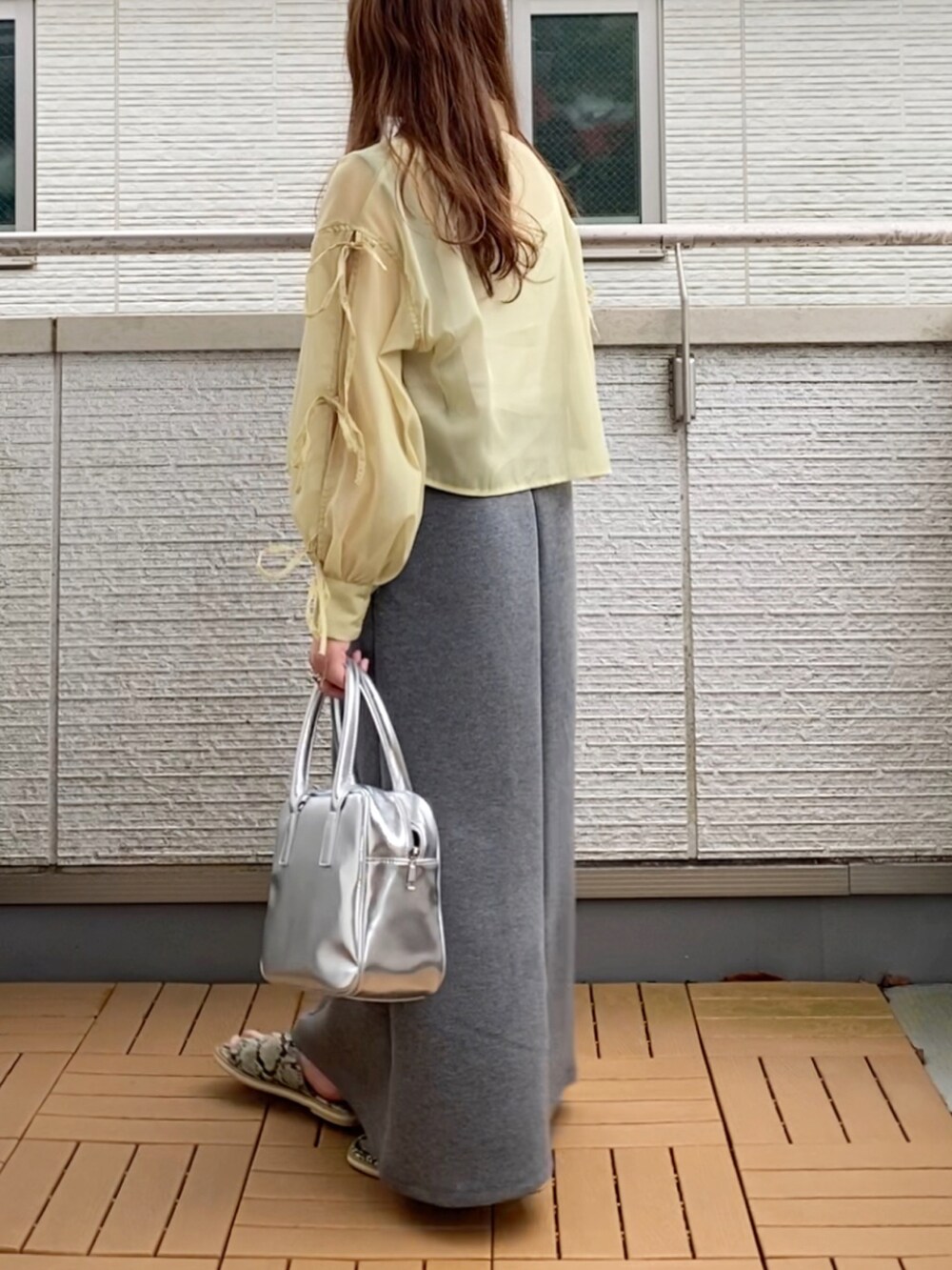 イエロー系のシャツ/ブラウス、グレー系のワンピース、シルバー系のボストンバッグを着用したレディースの夏コーディネートの3枚目の写真