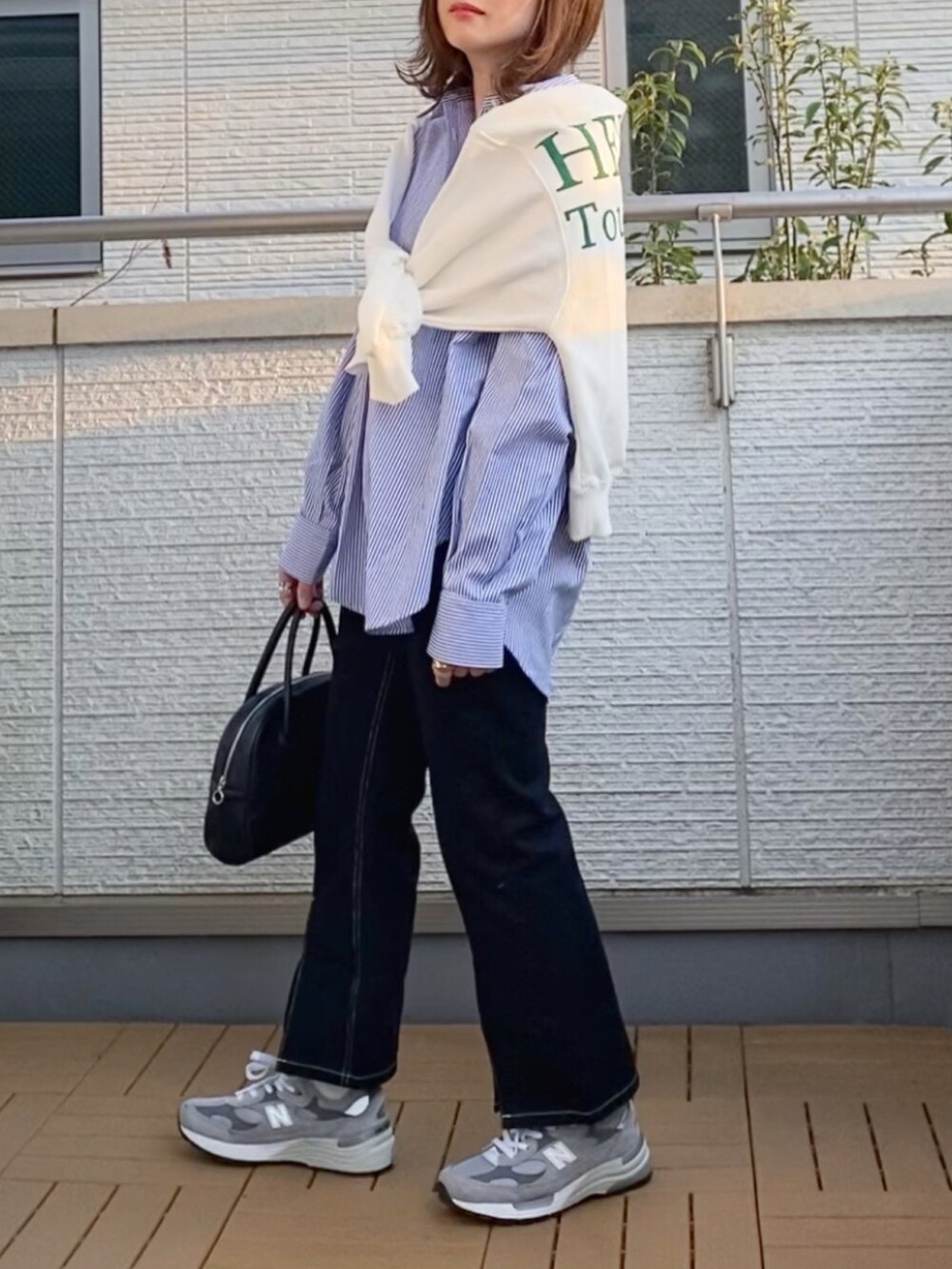 ブルー系のシャツ/ブラウス、ホワイト系のTシャツ/カットソー、ブラック系のデニムパンツを着用したレディースの春コーディネートの2枚目の写真