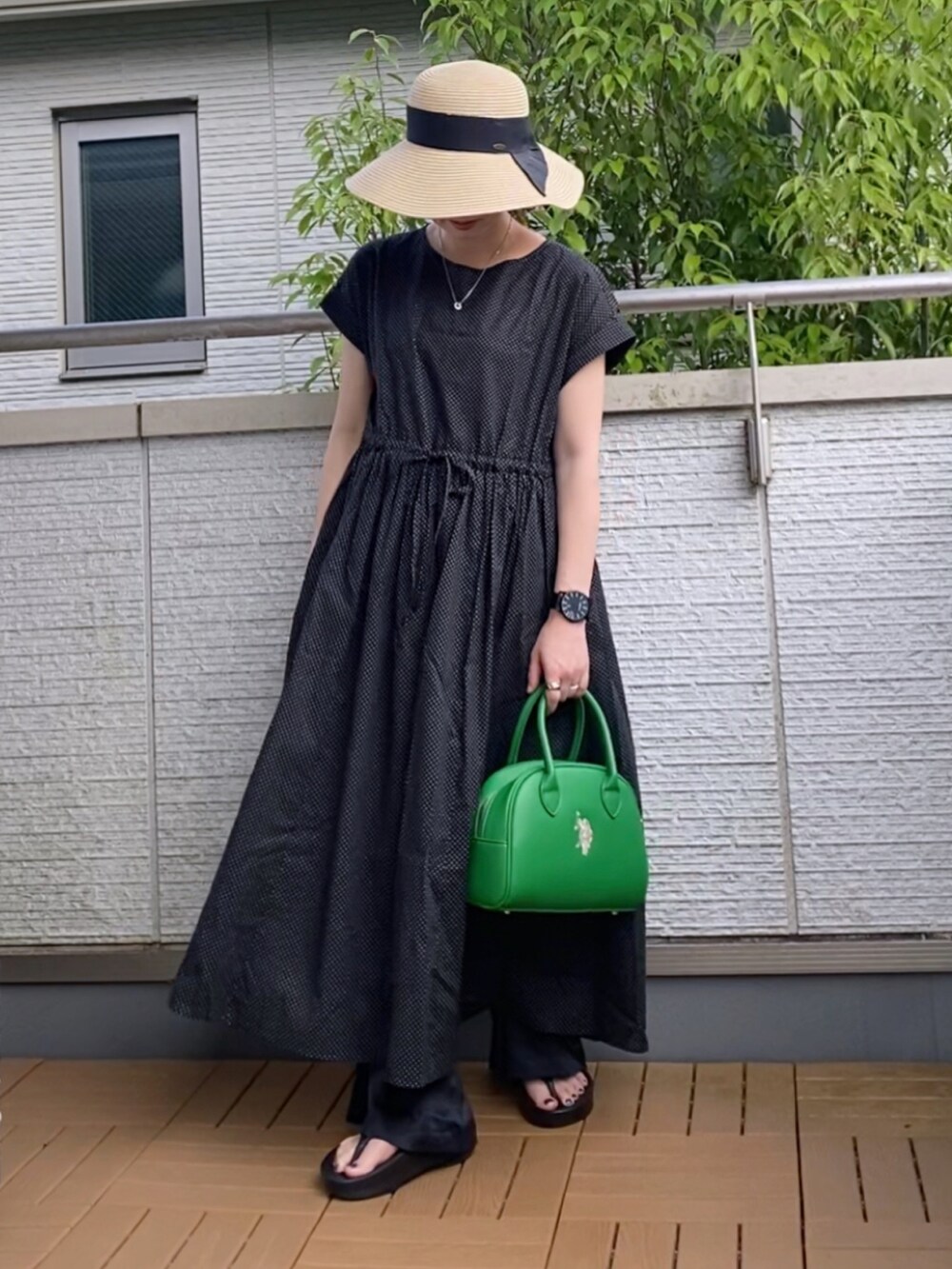 ブラック系のワンピース、ブラック系のその他パンツ、グリーン系のハンドバッグを着用したレディースの夏コーディネートの3枚目の写真