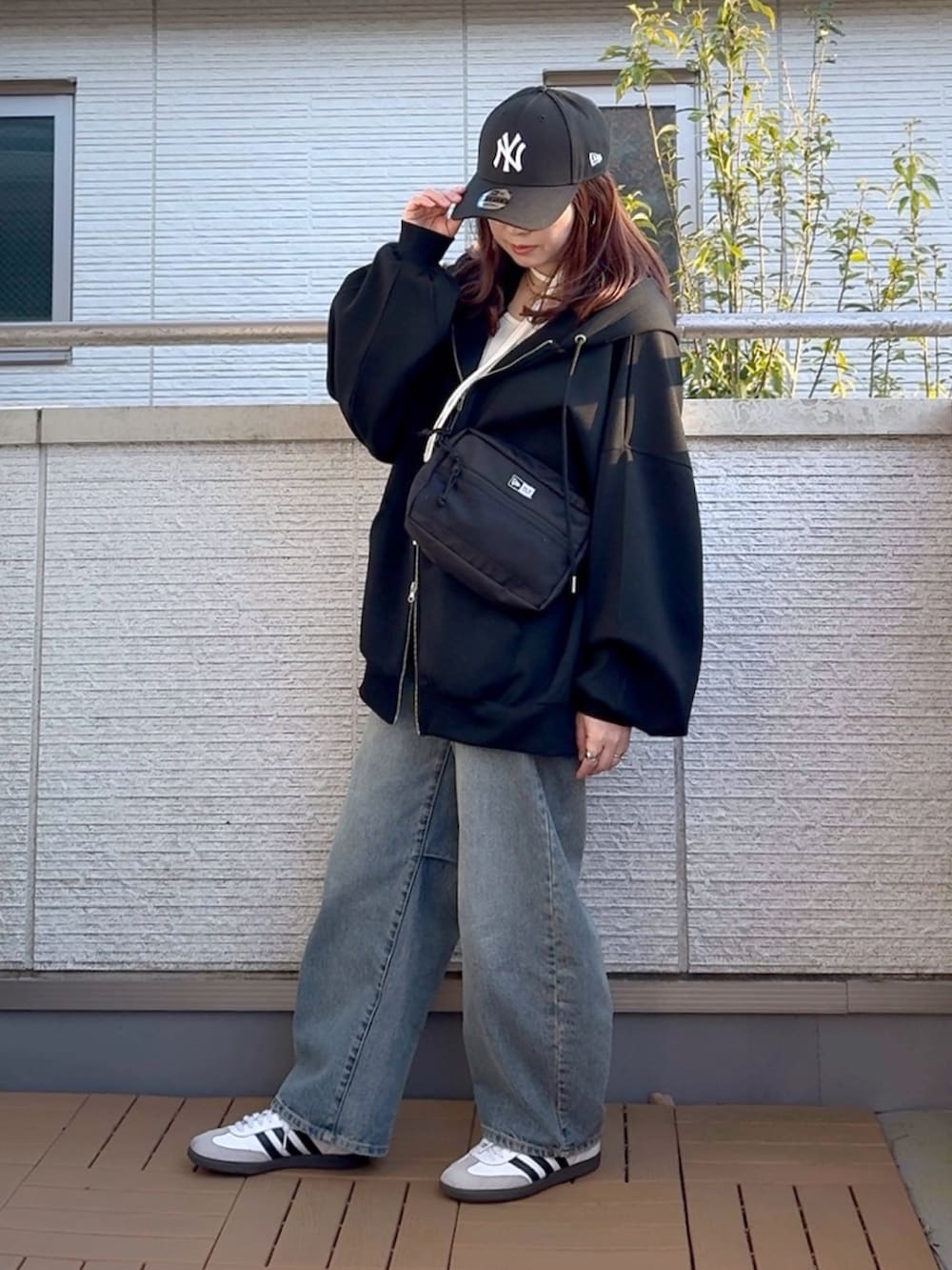 ブラック系のパーカー、ホワイト系のTシャツ/カットソー、ブラック系のショルダーバッグを着用したレディースの春コーディネートの2枚目の写真