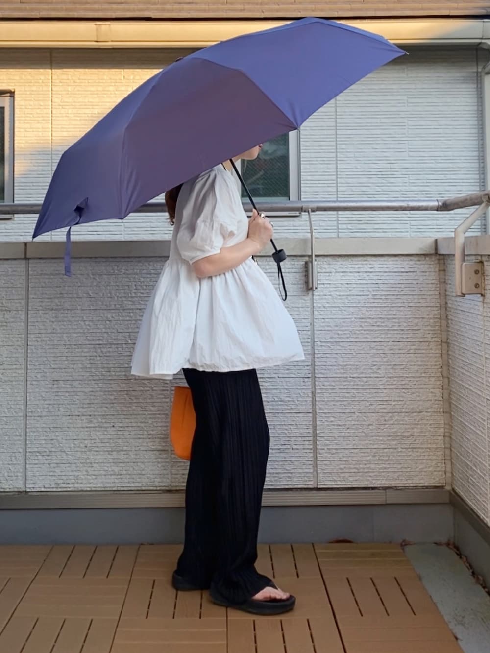 ホワイト系のTシャツ/カットソー、ブラック系のその他パンツ、オレンジ系のトートバッグを着用したレディースの夏コーディネートの3枚目の写真