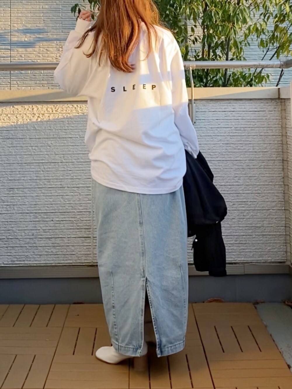 ホワイト系のTシャツ/カットソー、ブラック系のその他アウター、ブルー系のデニムスカートを着用したレディースの春コーディネートの4枚目の写真