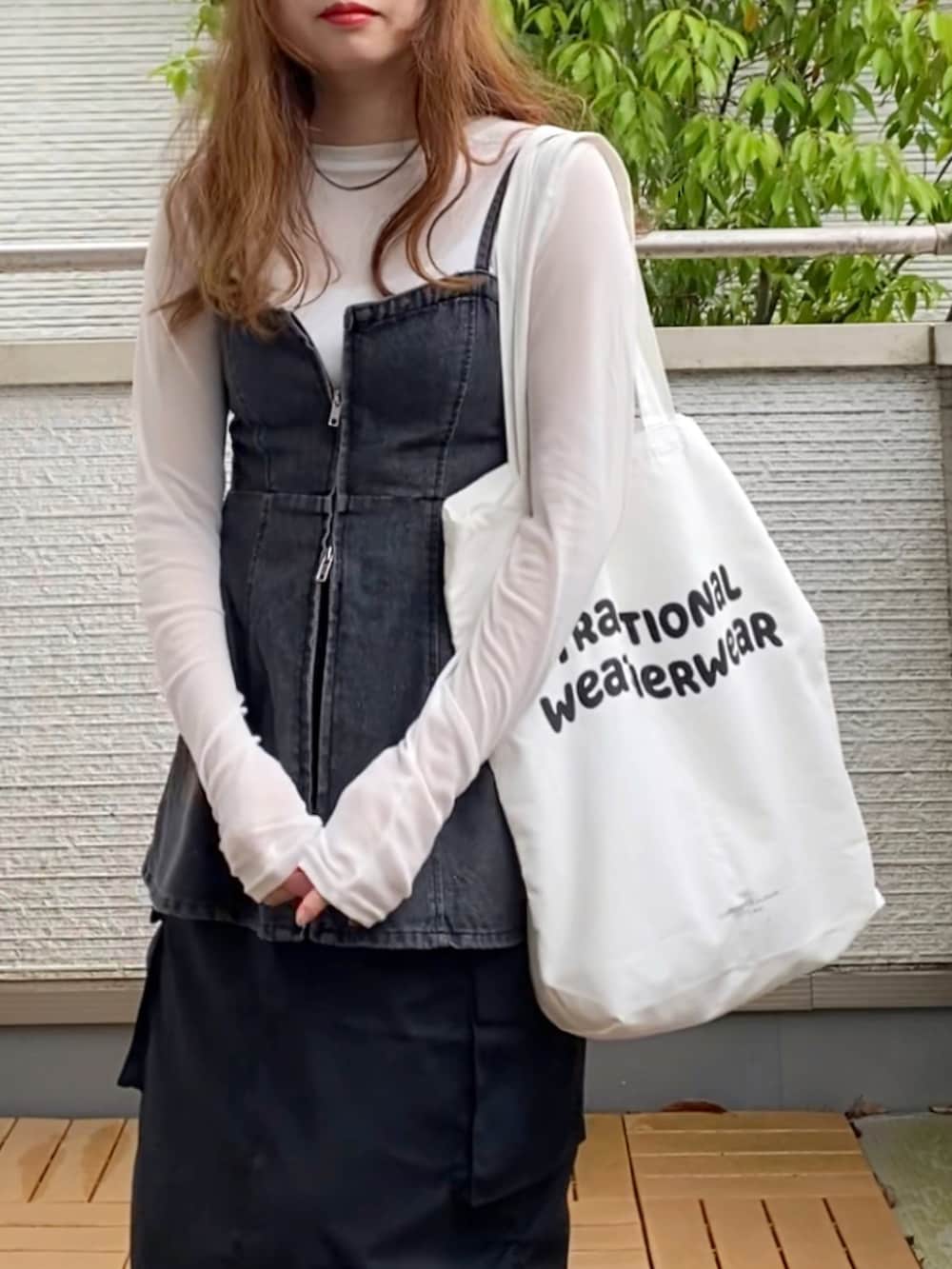 ホワイト系のTシャツ/カットソー、ブラック系のベスト、ブラック系のスカートを着用したレディースの春コーディネートの5枚目の写真