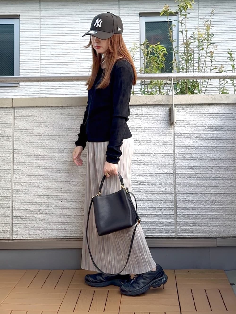 ブラック系のTシャツ/カットソー、グレー系のスカート、ブラック系のショルダーバッグを着用したレディースの秋コーディネートの3枚目の写真