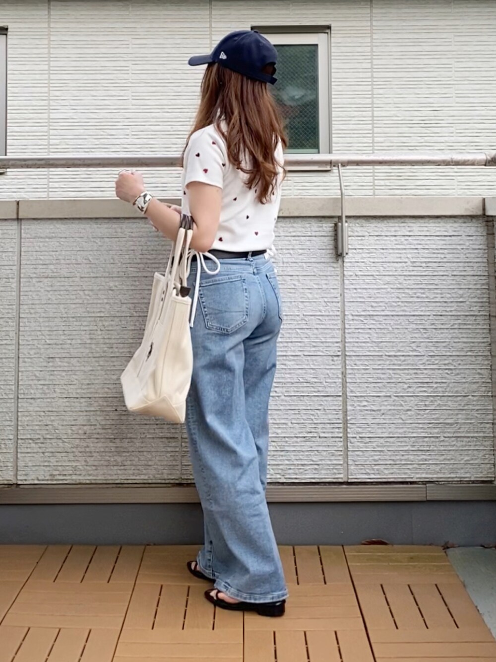 ホワイト系のTシャツ/カットソー、ブルー系のデニムパンツ、ホワイト系のトートバッグを着用したレディースの夏コーディネートの2枚目の写真