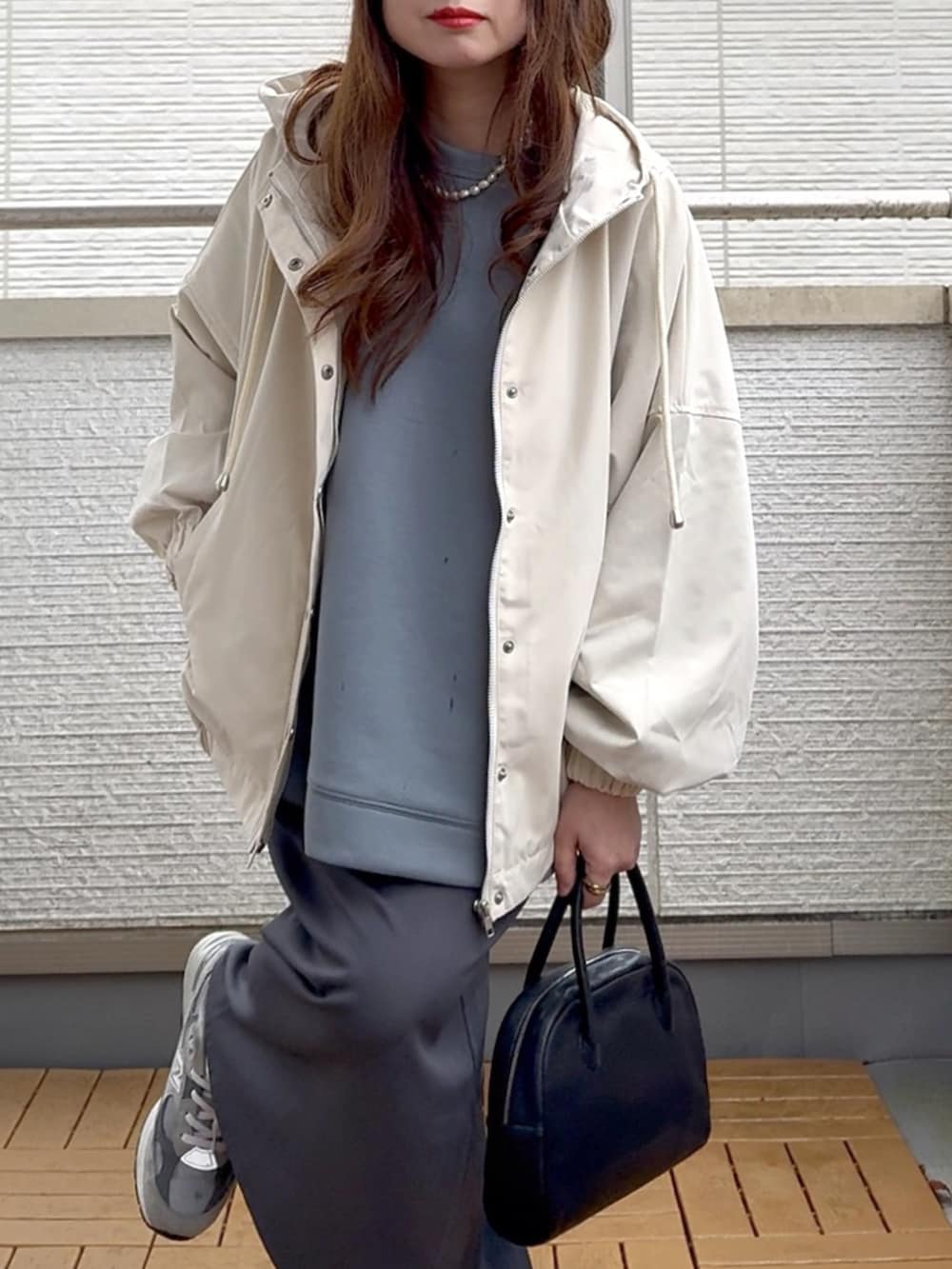 ホワイト系のマウンテンパーカー、ブルー系のスウェット、グレー系のスカートを着用したレディースの春コーディネートの5枚目の写真