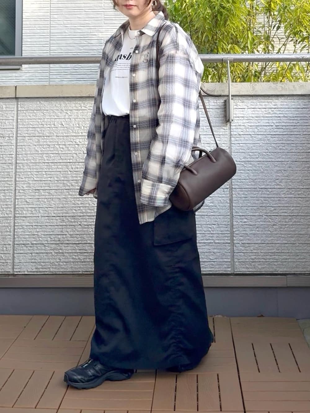 ホワイト系のシャツ/ブラウス、ブラック系のスカート、ブラック系のスニーカーを着用したレディースの春コーディネートの2枚目の写真