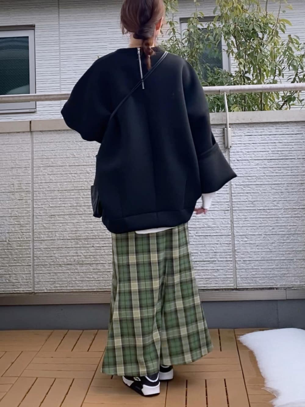 ブラック系のスウェット、グリーン系のスカート、ブラック系のショルダーバッグを着用したレディースの冬コーディネートの3枚目の写真