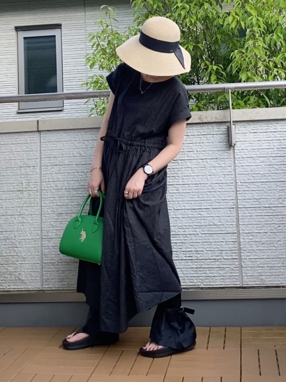ブラック系のワンピース、ブラック系のその他パンツ、グリーン系のハンドバッグを着用したレディースの夏コーディネートの4枚目の写真