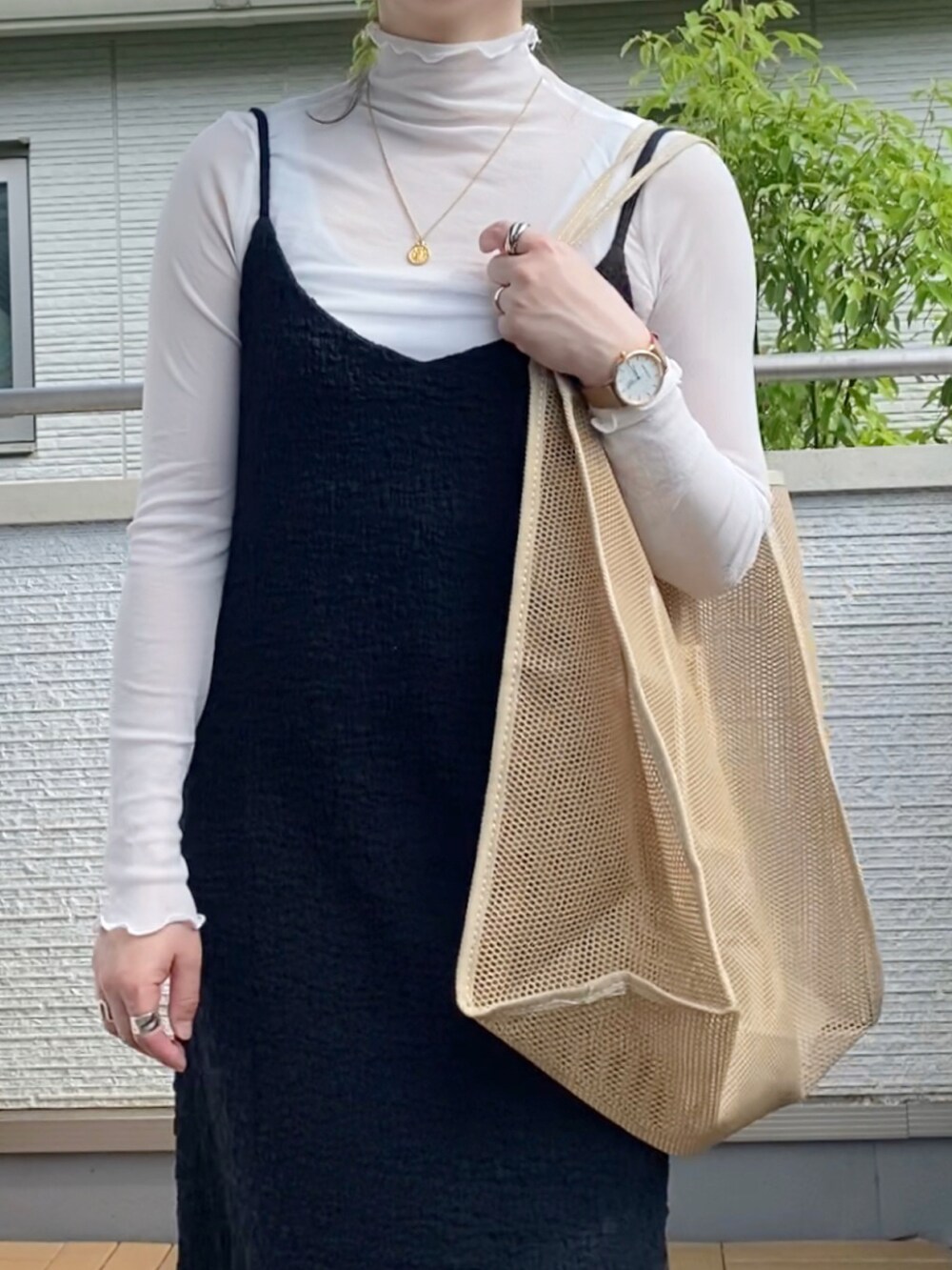 ブラック系のワンピース、ホワイト系のTシャツ/カットソー、ベージュ系のエコバッグ/サブバッグを着用したレディースの夏コーディネートの2枚目の写真