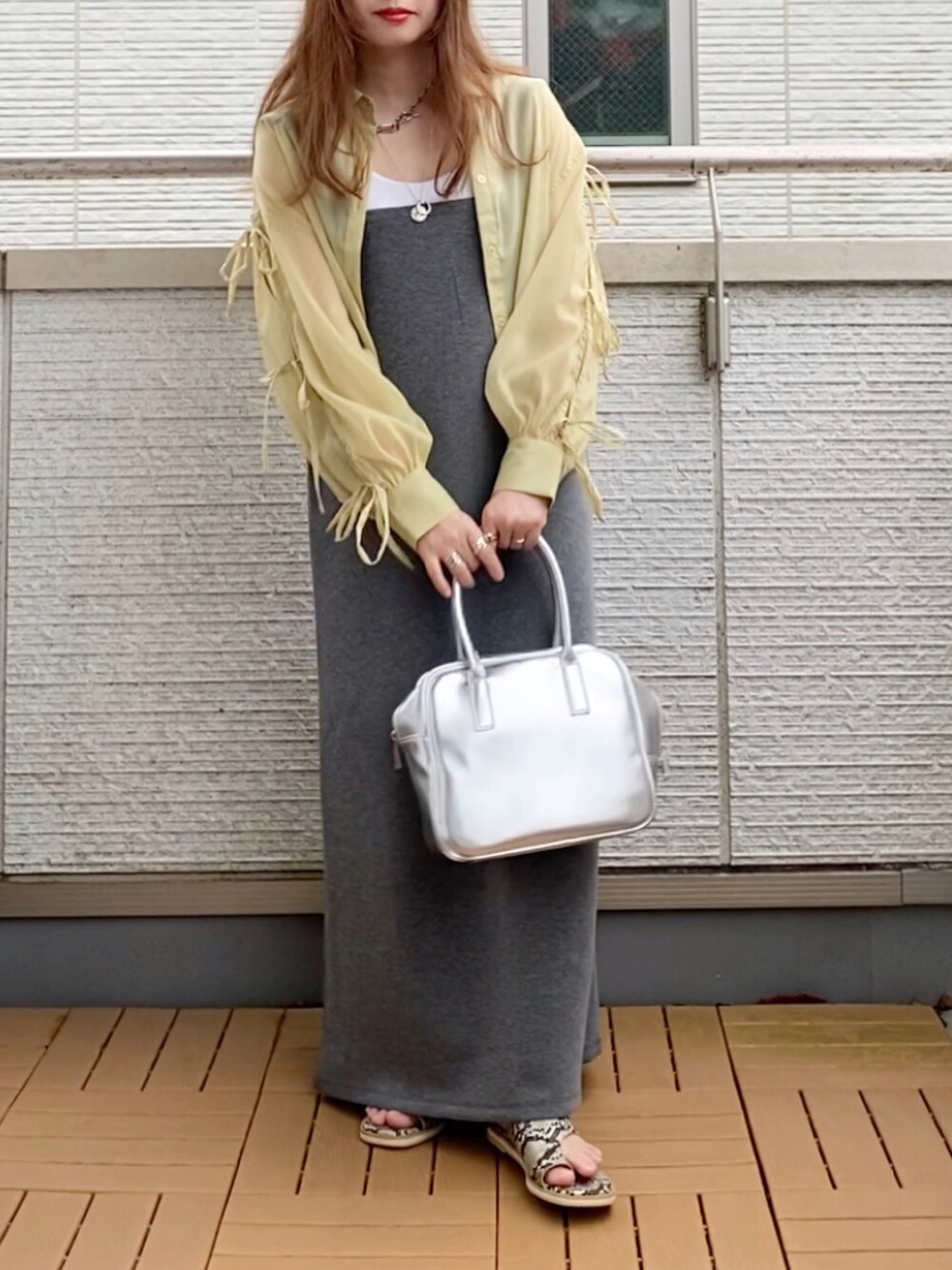 イエロー系のシャツ/ブラウス、グレー系のワンピース、シルバー系のボストンバッグを着用したレディースの夏コーディネートの2枚目の写真